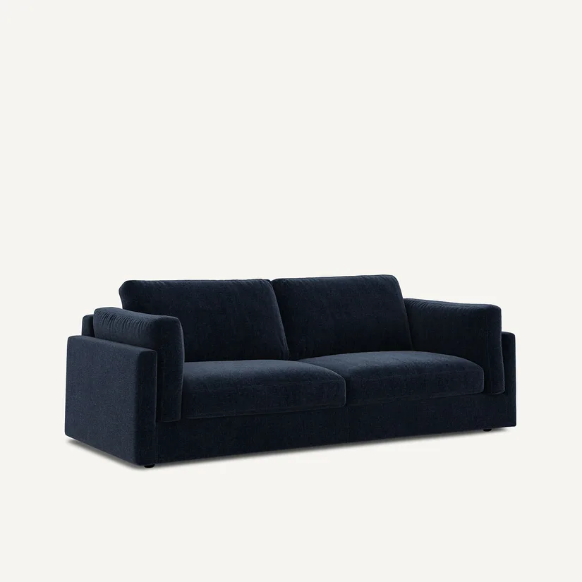 Canapé César bleu marine en velours chenille, vu de trois quarts, coussins fermés, sur fond clair.