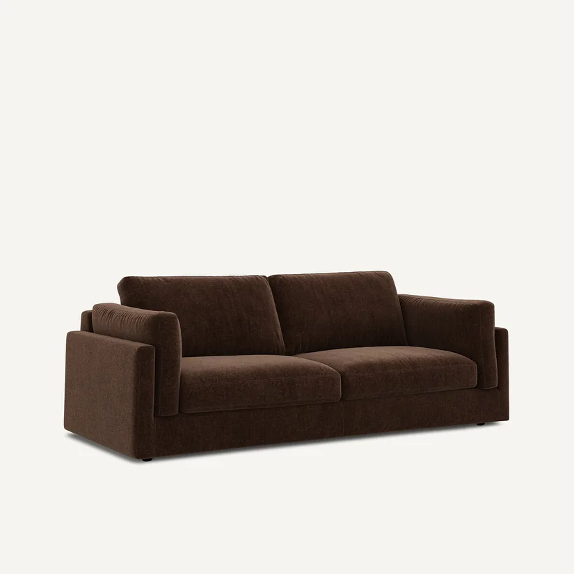 Canapé César marron foncé en velours chenille, vu de trois quarts, coussins fermés, sur fond clair.