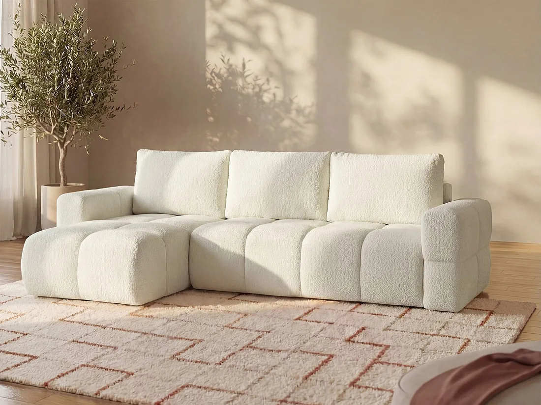 Canapé Issoro d'angle en bouclette blanche avec méridienne à gauche, posé sur un tapis beige.