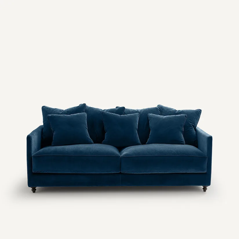 Canapé Lazare bleu canard en velours, trois places avec nombreux coussins, vu de face sur fond blanc.